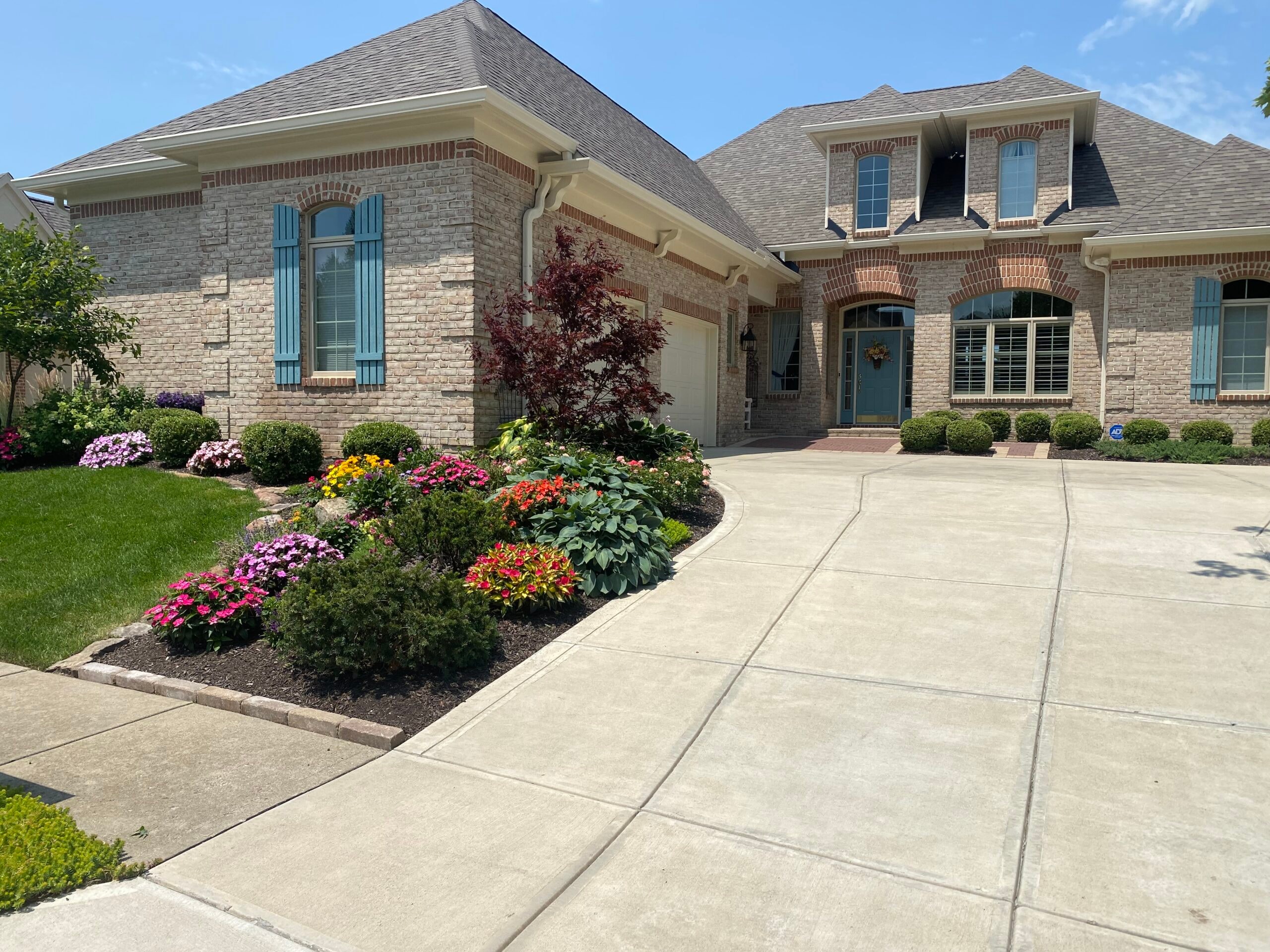 Brick home with colorful flower landscaping residential